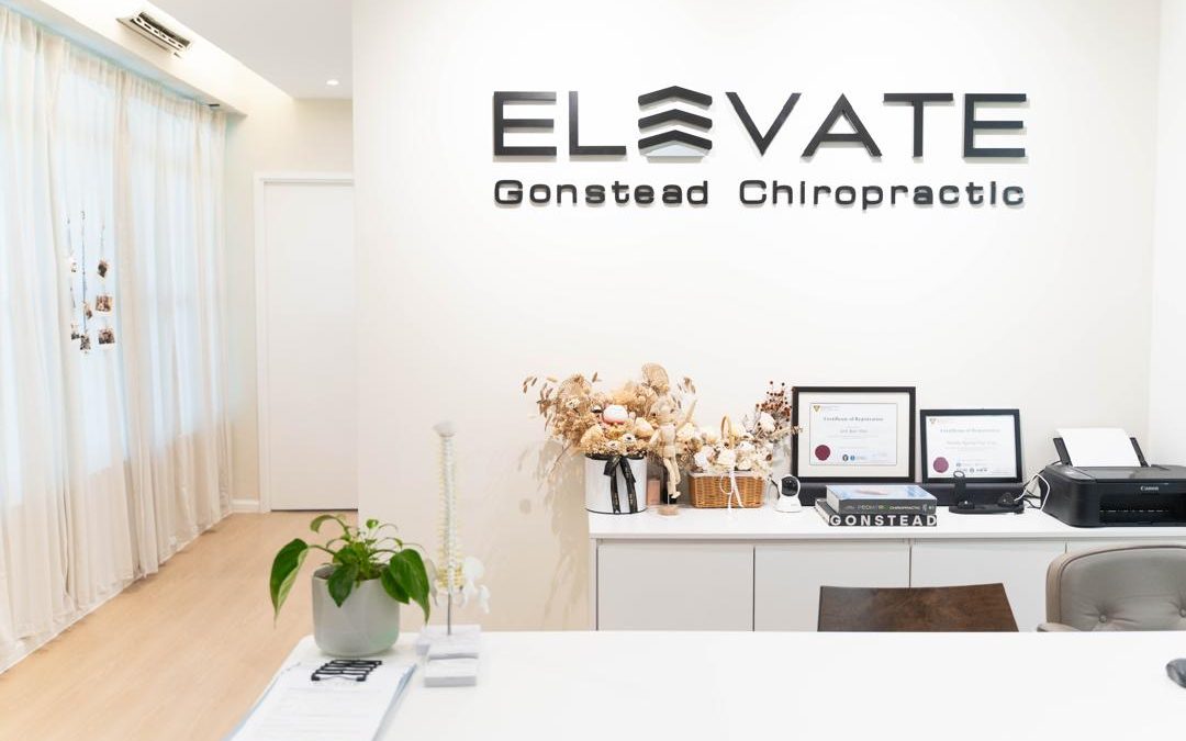 "Front desk of a Gonstead Chiropractic clinic, featuring a welcoming reception area with modern decor, friendly staff, and informational brochures about Gonstead chiropractic care."