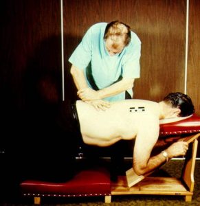 Dr. Clarence S. Gonstead teaching the knee chest table technique to chiropractic students.
