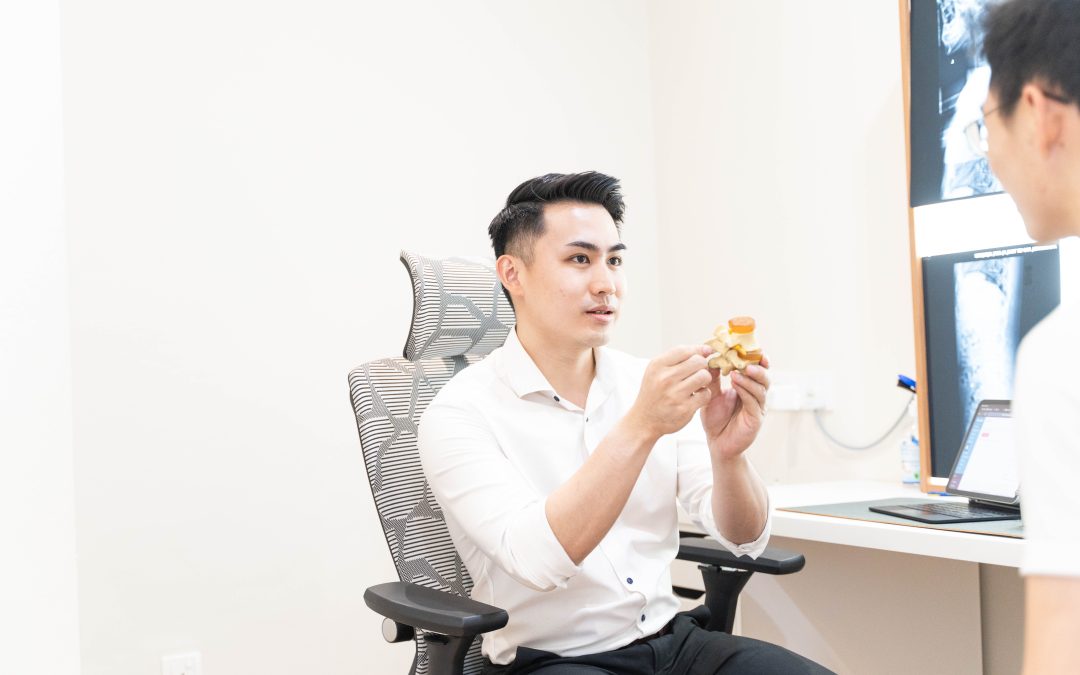 Chiropractor at Elevate Chiropractic explaining spinal anatomy using a model